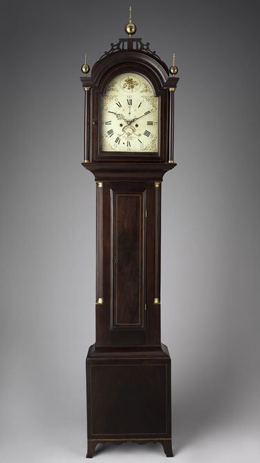 Photograph of a tall clock composed from mahogany with a white pine face
