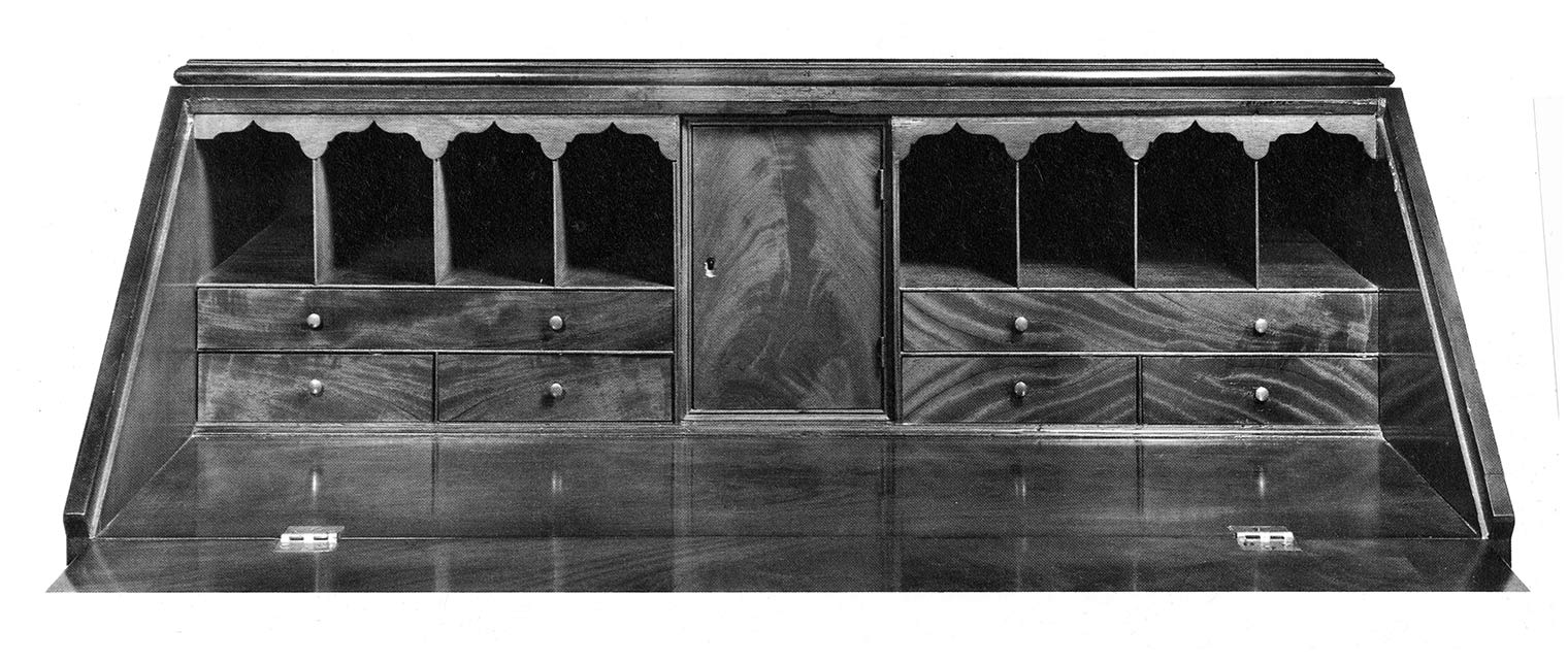Black-and-white photograph of the desk portion of a desk and bookcase