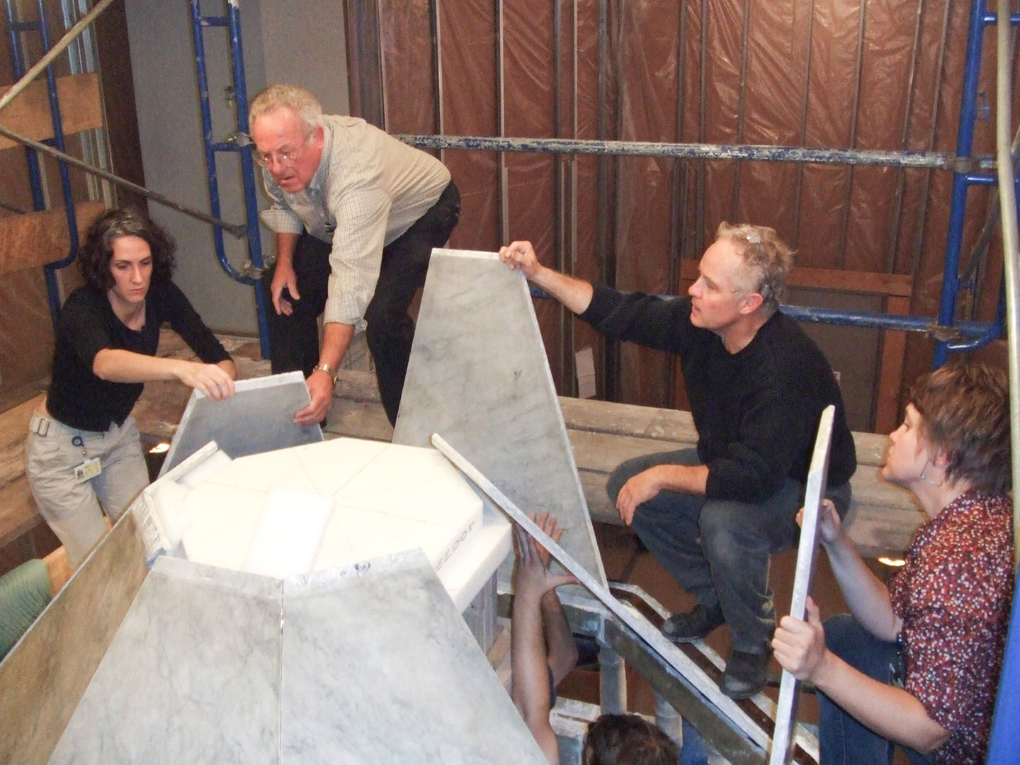 Sari Uricheck, Franz Schmidt, Michael Morris, and Carolyn Riccardelli work together to fit the ciborium's octagonal roof sections into place.