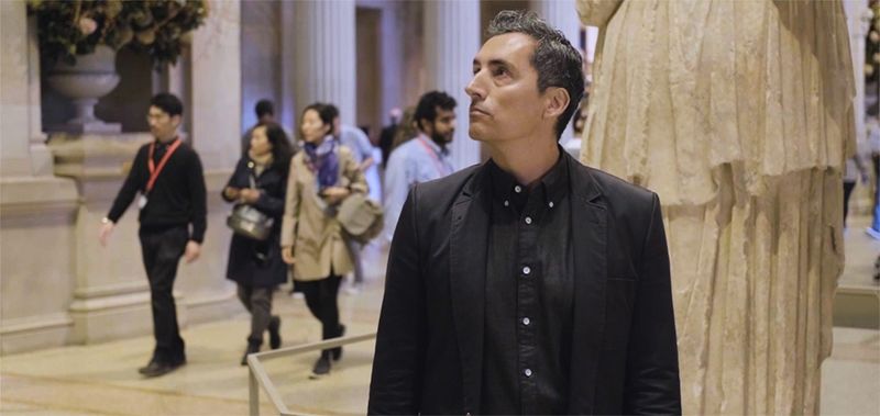 A artist Kent Monkman stands in The Met's Great Hall, looking around