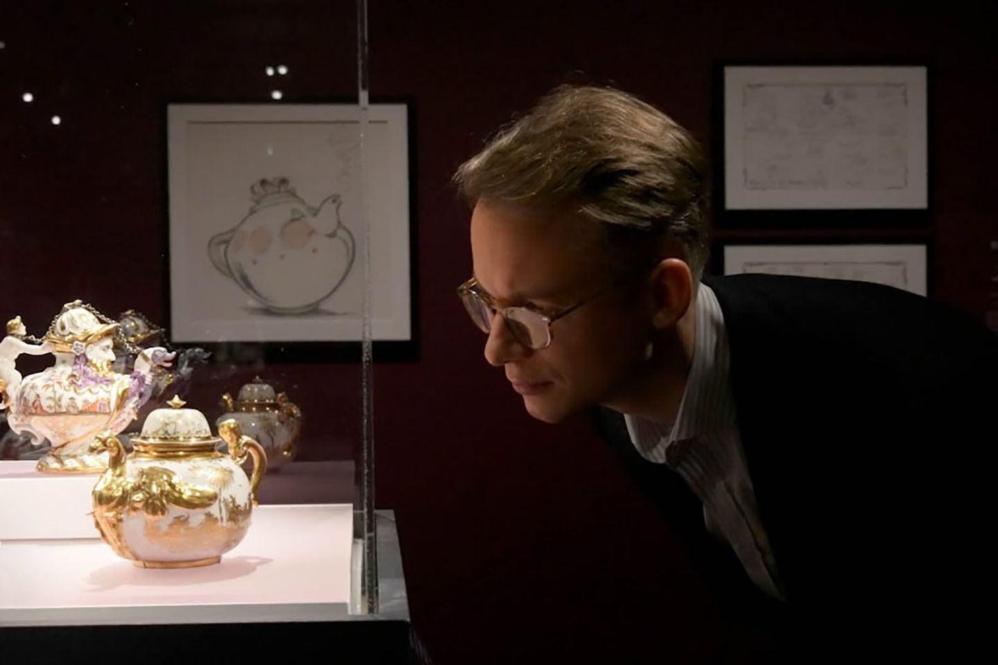 Curator Wolf Burchard looking at Rococo porcelain on display in 