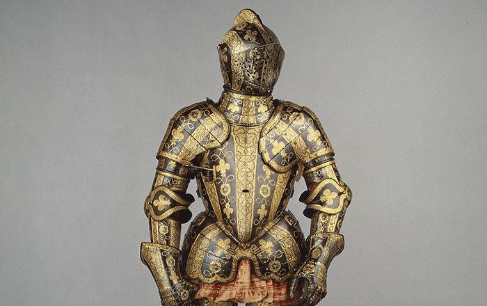 A suit of armor highly decorated with geometrical and floral patterns, blackened and gilded