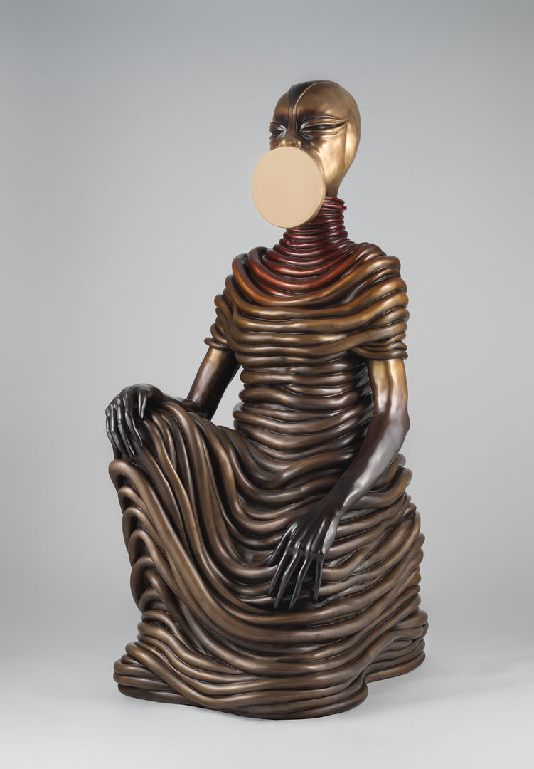Bronze sculpture of a seated female figure; the entire figure is draped with coils.