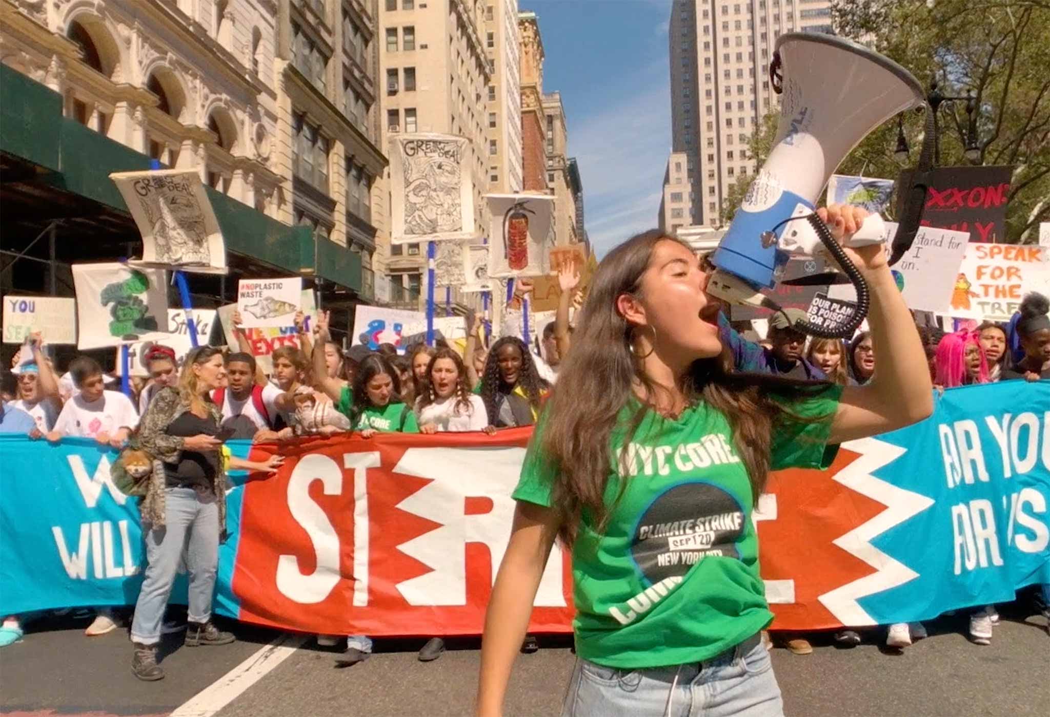 Indigenous American climate justice activist Xiye Bastida shouts into a megaphone in front of a large-scale protest
