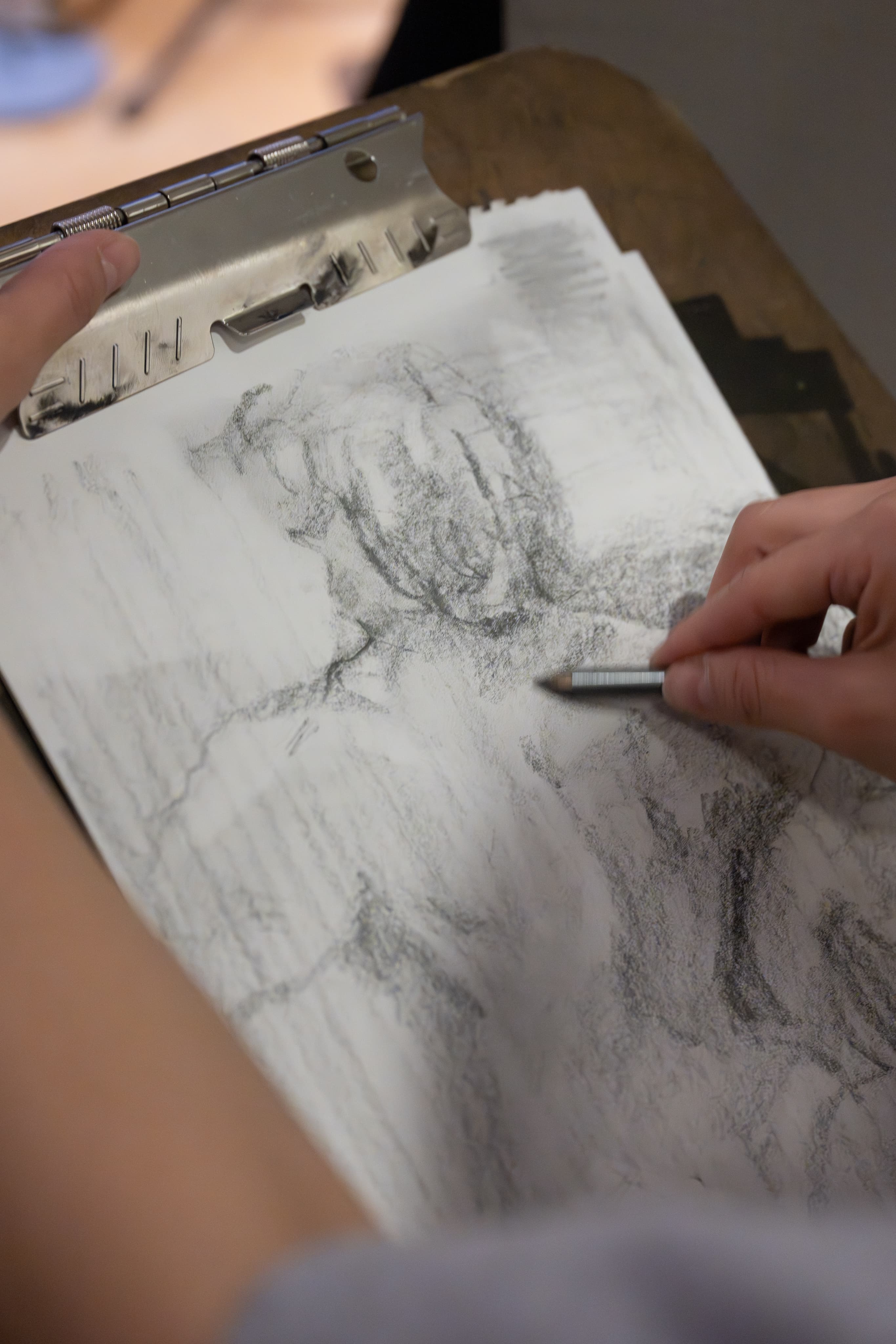 Hands of program participant drawing.