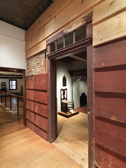 Exterior of the Dutch Room at The Met. Through the door, a wooden chair and the mantlepiece are visible.