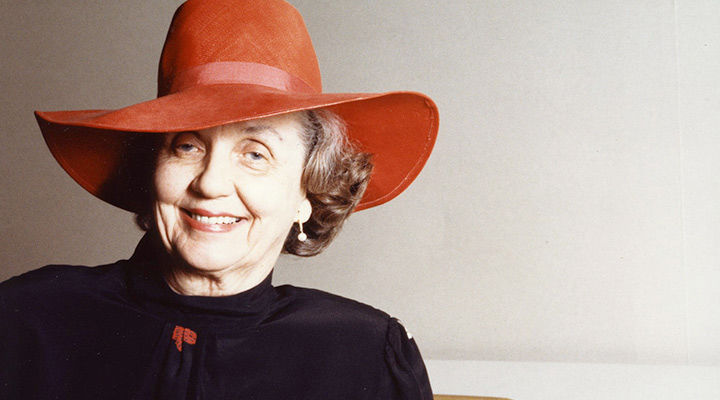 Photo of Mary Griggs Burke wearing a large red hat and a black shirt