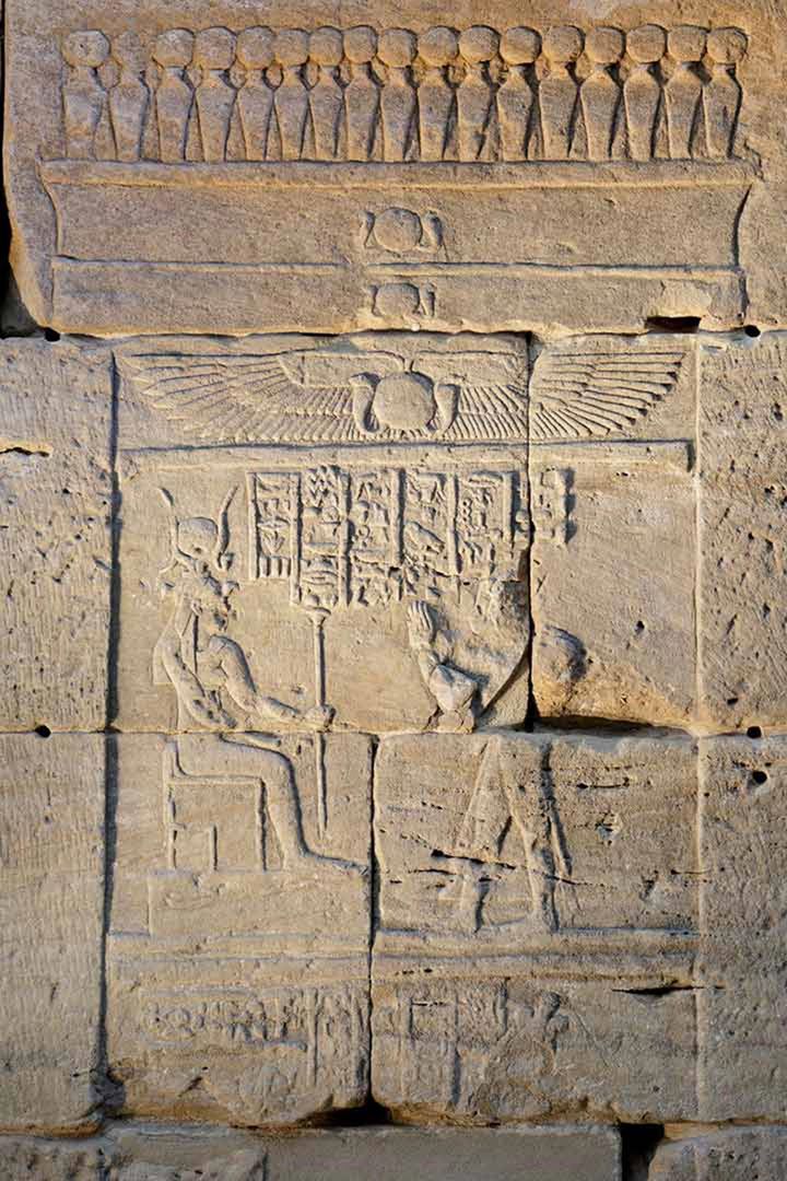 Left: Detail depicting a shrine with a frieze of cobras at the top. In the scene below is a depiction of Pihor (right) offering to Isis (left).