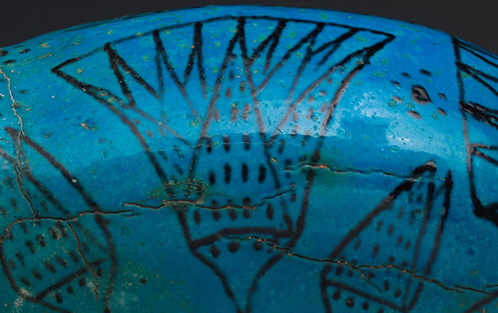 Detail of blue ceramic painted with black lotus flower design