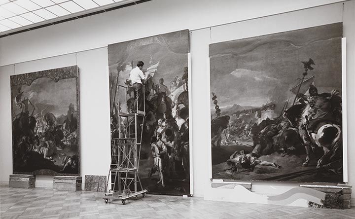 A conservator stood on a ladder working on Tiepolo’s The Triumph of Marius 