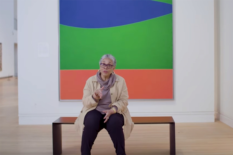 Lowery Stokes Simm's sitting on a bench in front of Ellsworth Kelly's Blue Green Red.