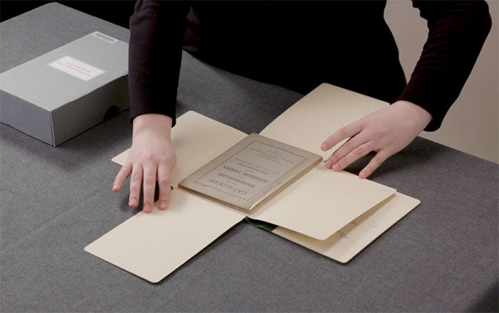A librarian demonstrating care and handling of delicate published materials