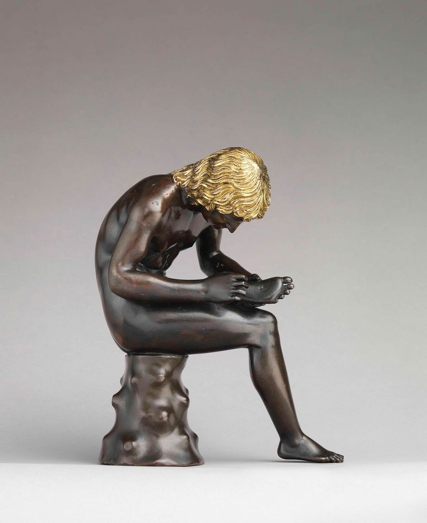 Antico (Pier Jacopo Alari Bonacolsi) (Italian, ca. 1460–1528). Spinario (Boy Pulling a Thorn from His Foot), probably modeled by 1496, cast ca. 1501. Italian, Mantua. Bronze, partially gilt (hair) and silvered (eyes); H. 7 3/4 in. (19.7 cm); W. of base 2 15/16 in. (7.5 cm). The Metropolitan Museum of Art, New York, Gift of Mrs. Charles Wrightsman, 2012 (2012.157)