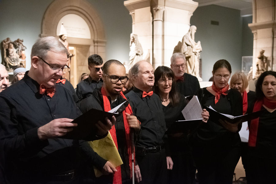 A choir group dressed in all black singing in The Fuentidueña Chapel.