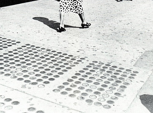 [Legs of Woman in Circle Pattern Dress Walking Past Sidewalk Skylights, New York City]