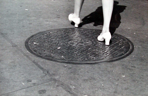 [Legs of Woman Walking Across Manhole Cover, New York City]