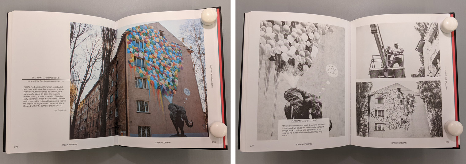 Open book with a photograph of a mural of an elephant holding a large bunch of colored balloons