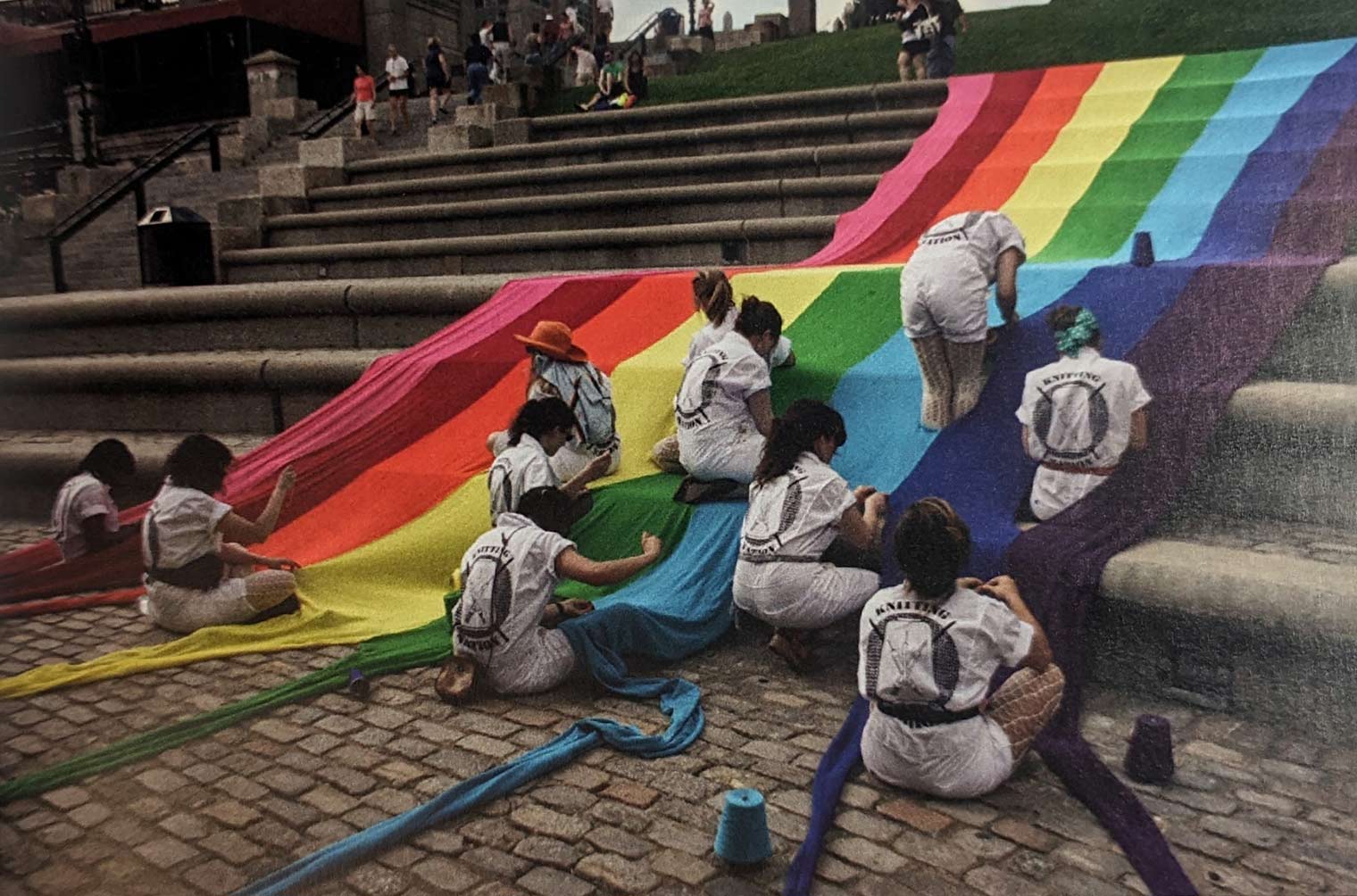 Pride flag being draped over a large public staircase
