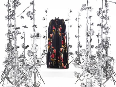 A dress with flowers are surrounded by large metal pieces of equipment