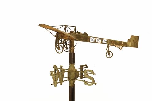 A gold weathervane with a sculpted plane
