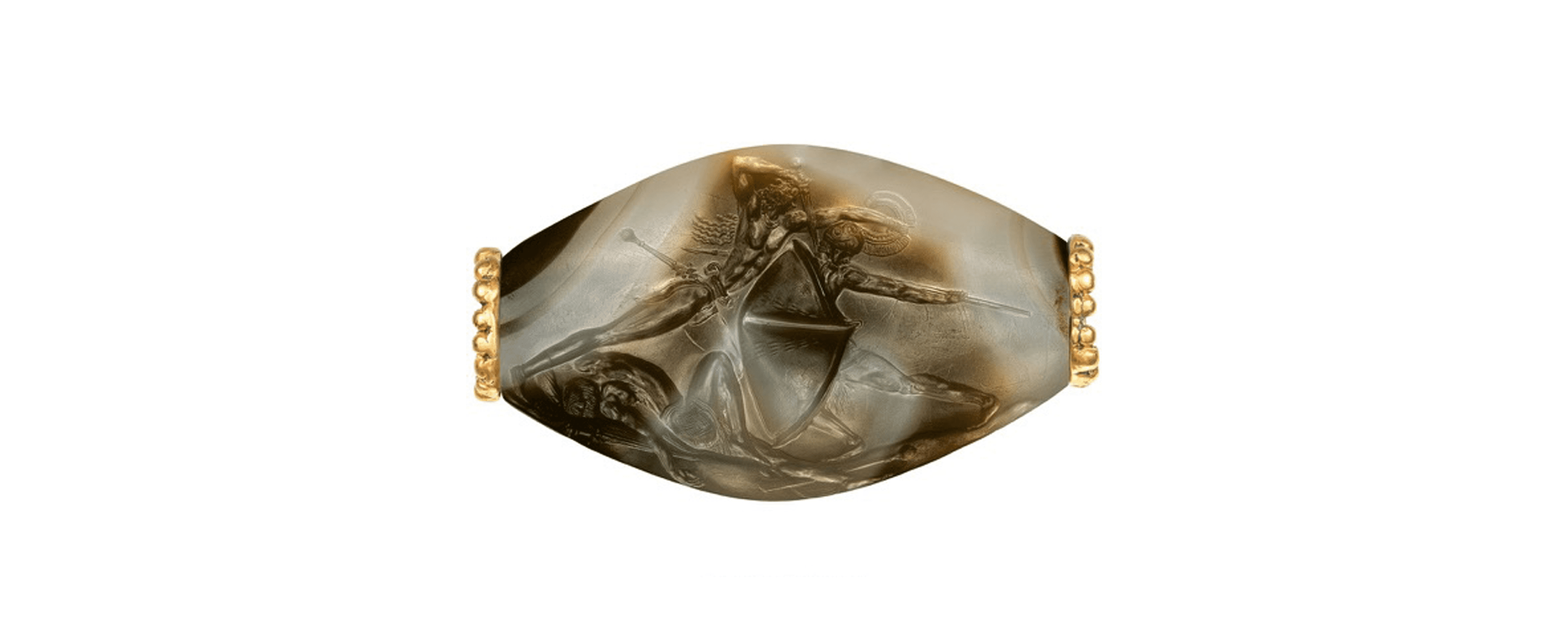 A carved stone, marbled with browns and whites, with gold fasteners on either end.